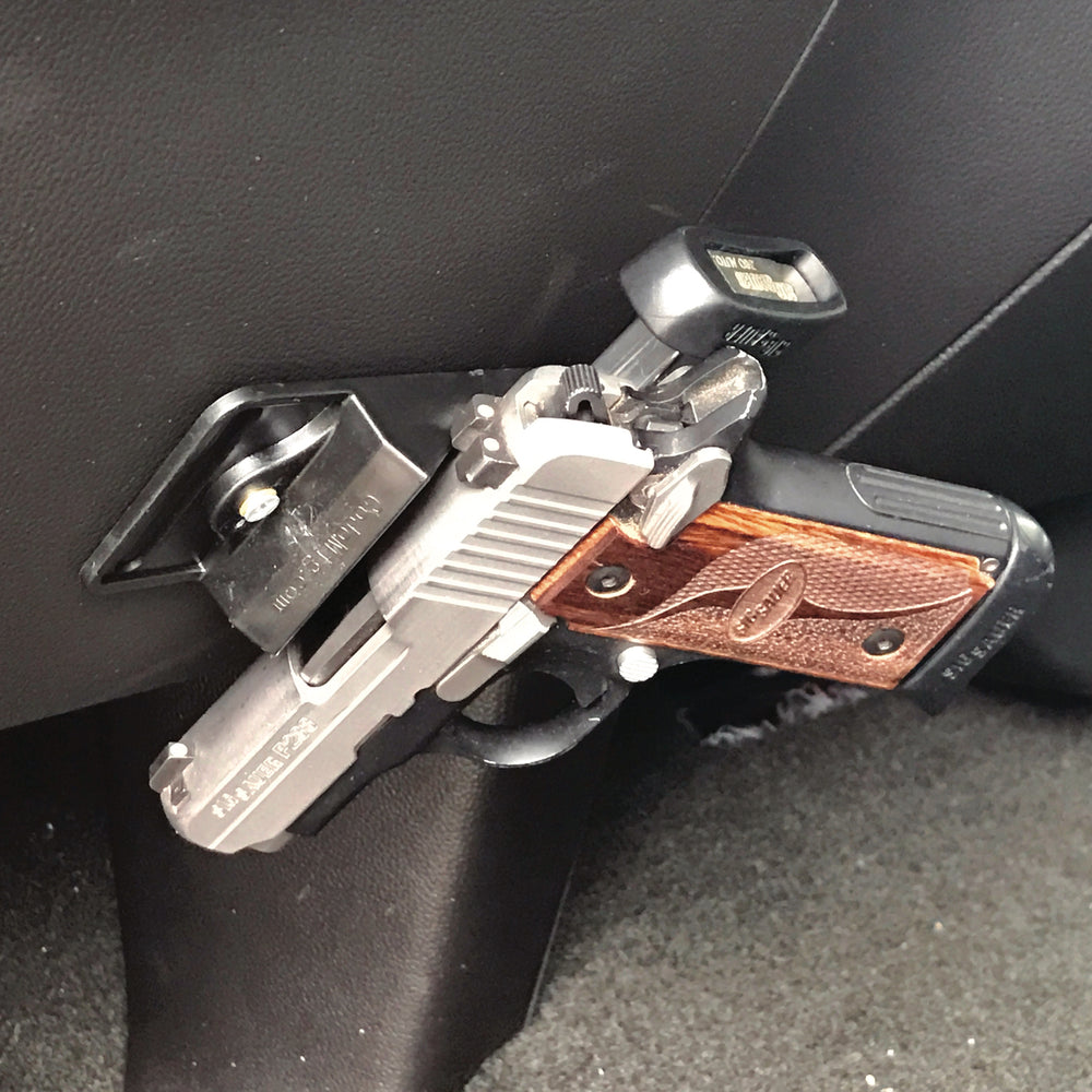 CoJo gun magnet holding a gun and a extra magazine under the dash of a car.