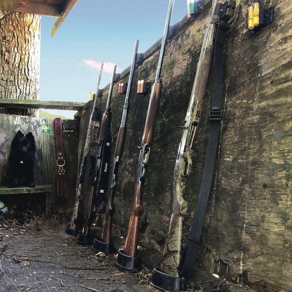 Six shotguns sitting in a Cojo Assperatus securing the but of the shotguns in a duck blind to prevent a gun accident.