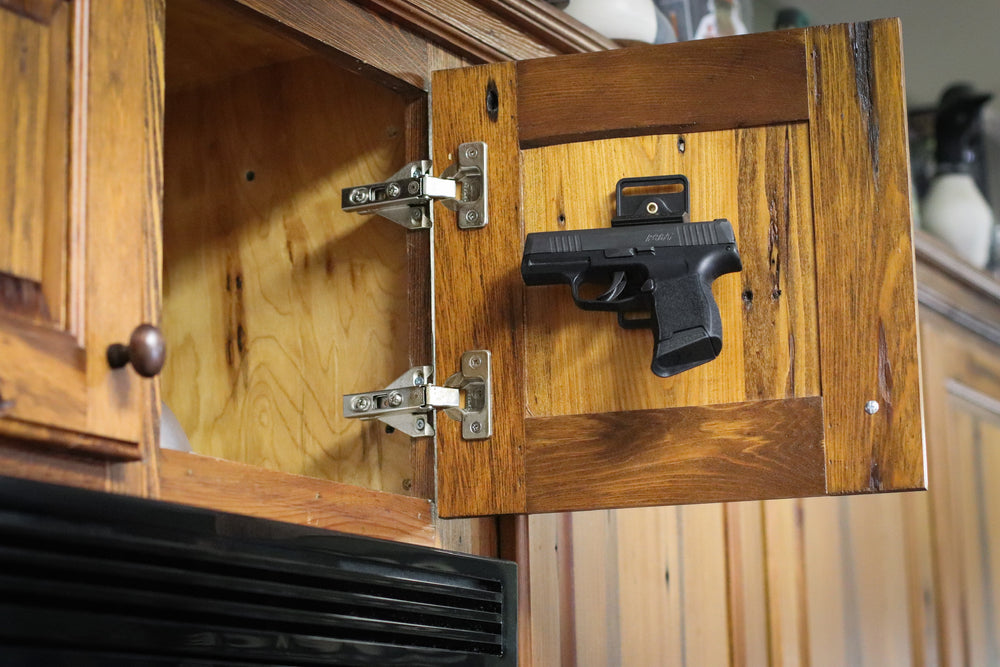 Cojo gun magnet holding a pistol in a kitchen cabinet.