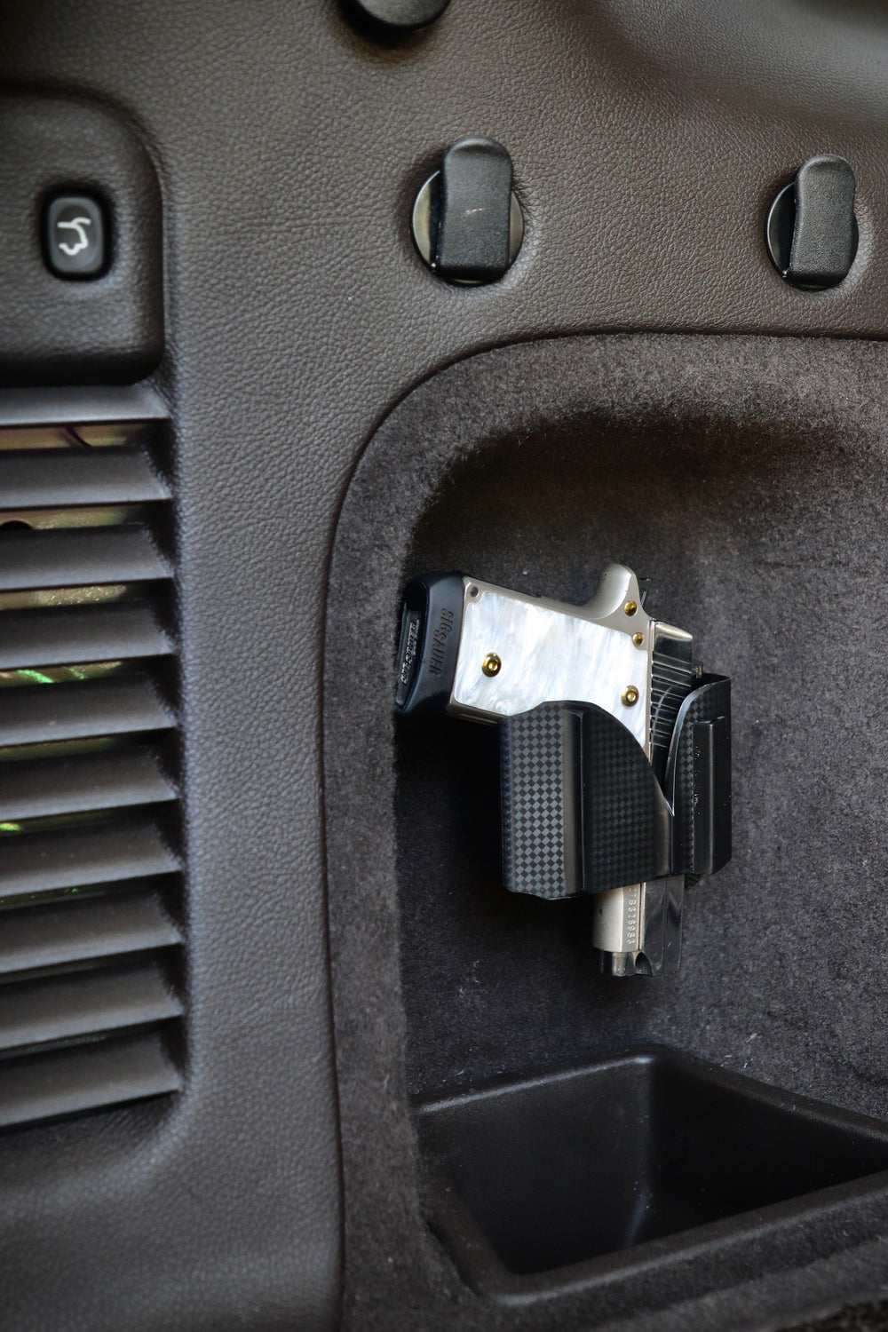 CoJo universal gun holster mounted in the side panel of a vehicle