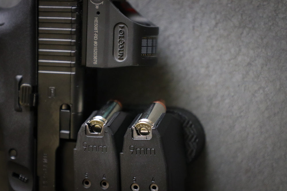 A pistol and two 9mm magazines held by a CoJo gun gripper gun magnet.