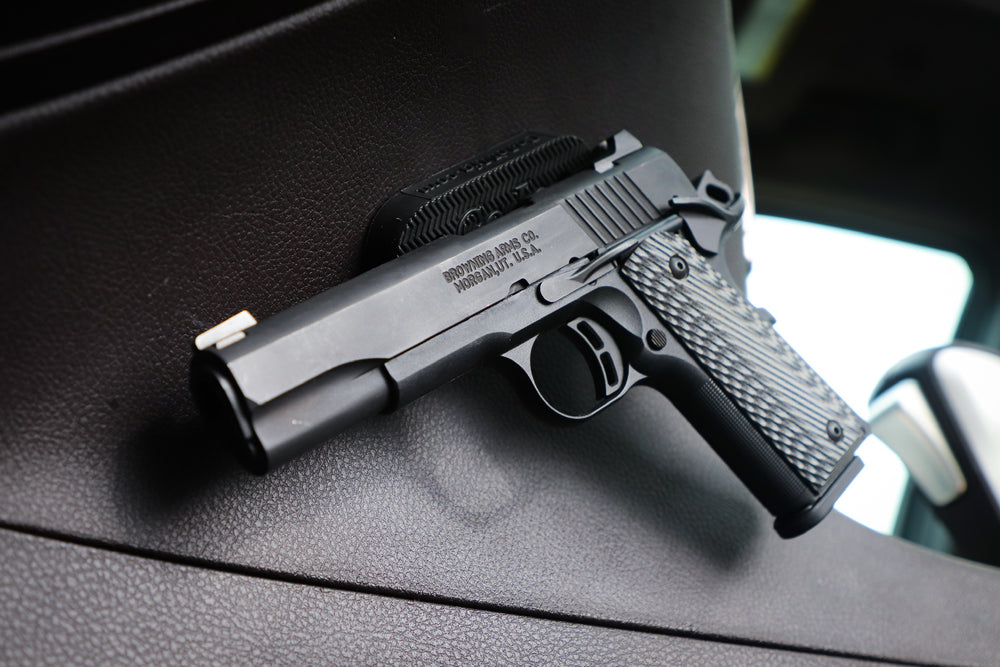 Semi Automatic pistol on a CoJo Gun Gripper mounted to the side of the console in a vehicle